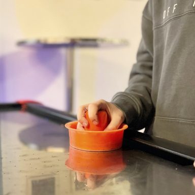 Ein Spieler positioniert einen Puck in einer roten Halterung auf einem Tisch.
