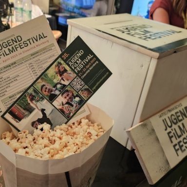 Popcornbehälter mit Informationen zum Jugendfilmfestival.