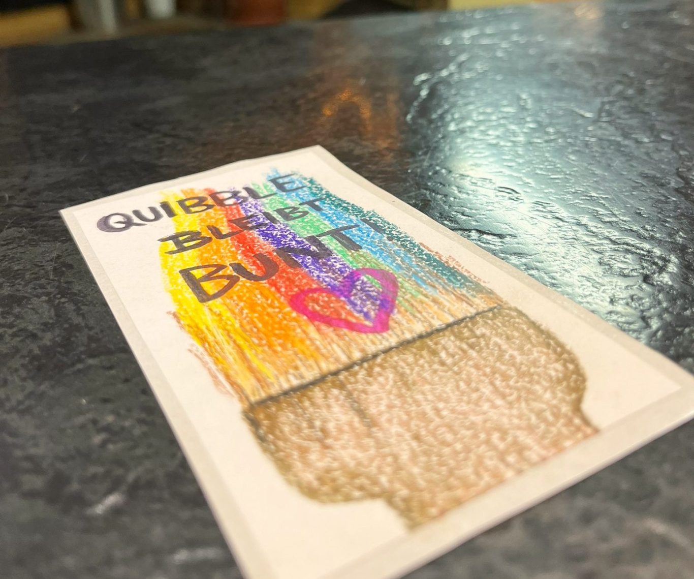 Bunte, künstlerische Darstellung eines Glases mit einem Herzen und dem Text "Querelle burs".