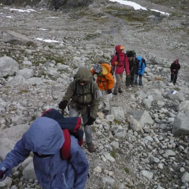 Eine Gruppe von Wanderern auf einem steinigen Pfad in den Bergen.