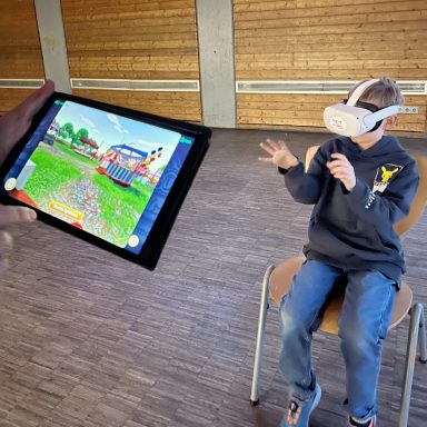Junge mit VR-Headset spielt, während ein Tablet mit Spielinhalt gehalten wird.