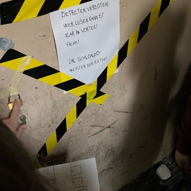 Ein Wandbereich mit gelben und schwarzen Warnstreifen und einem Hinweisblatt.