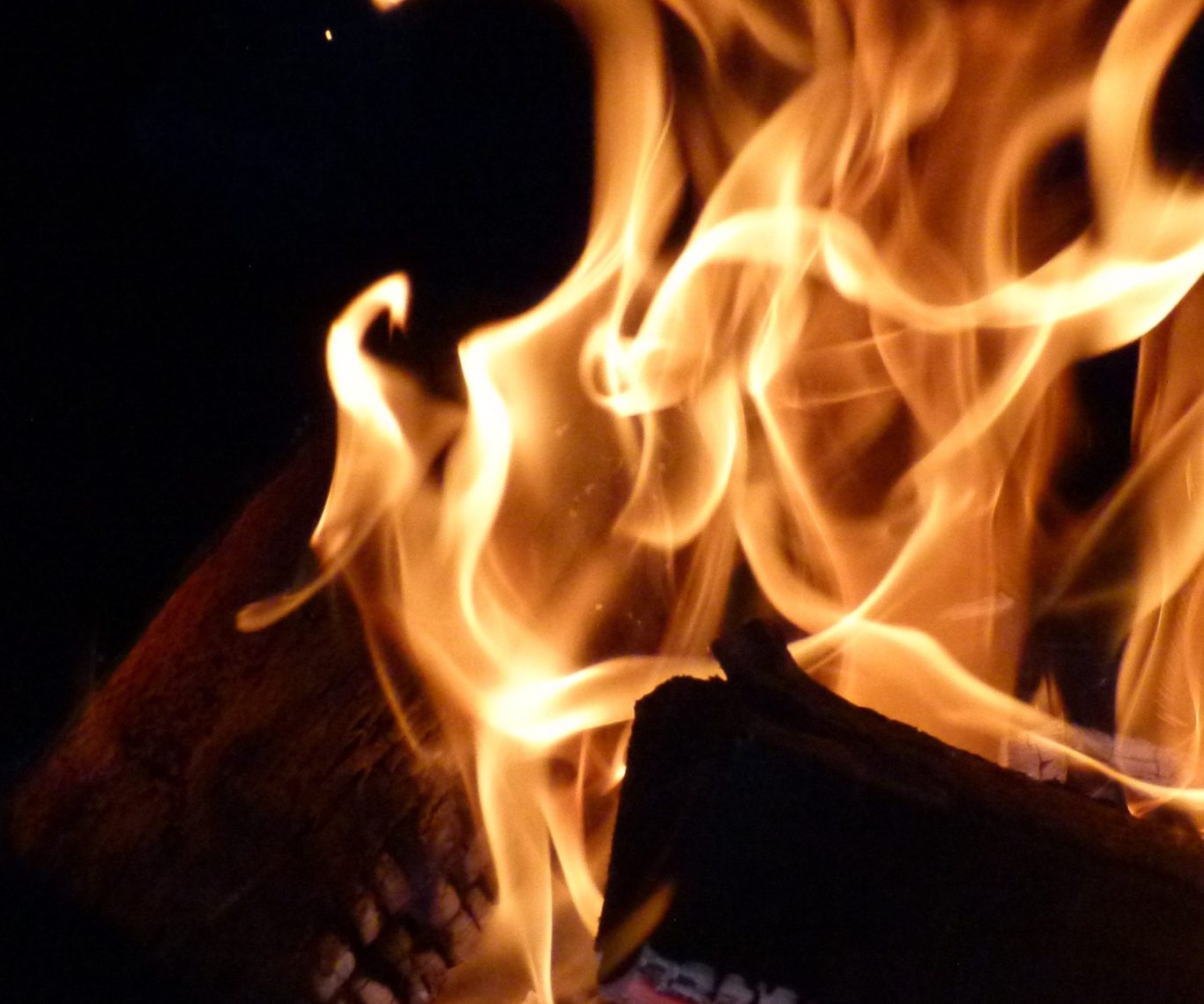 Flammendes Feuer mit tanzenden Zungen, die Holzscheite umgeben.